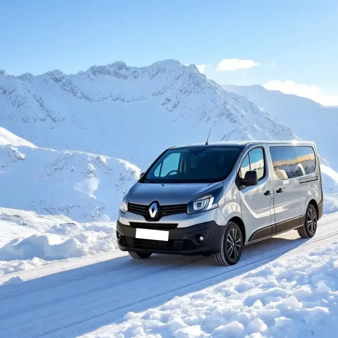 Véhicule Renault dans un paysage montagneux dans les Alpes enneigé sous un ciel bleu.